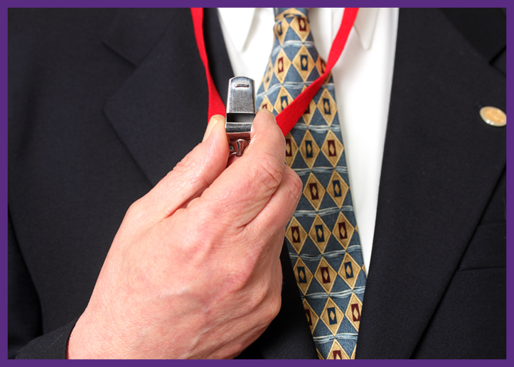 up close photo of a man in a suit holding a whistle in his hand 