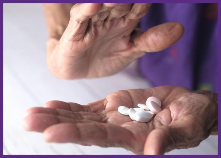 up close photo of a senior woman holding pills in her palm 
