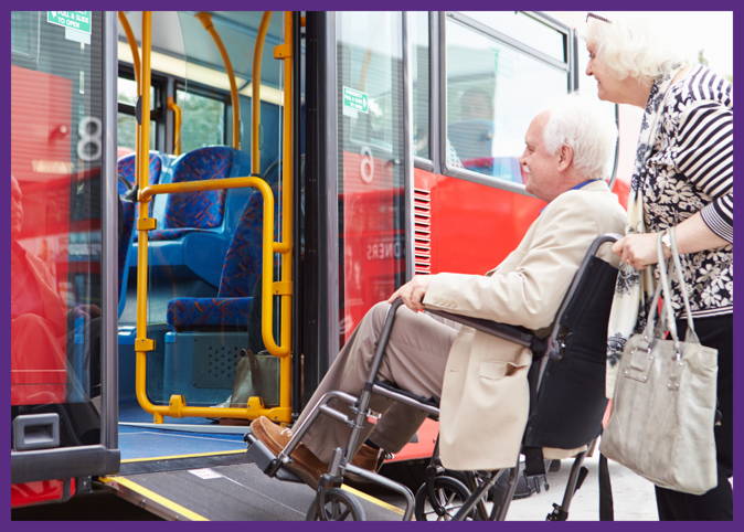 photo of a senior woman pushing her husband in a wheelchair up a ramp to get on a city bus 