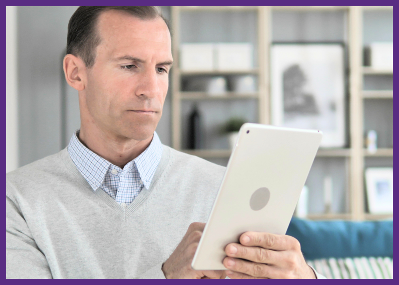 photo of a middle aged man typing on a tablet 